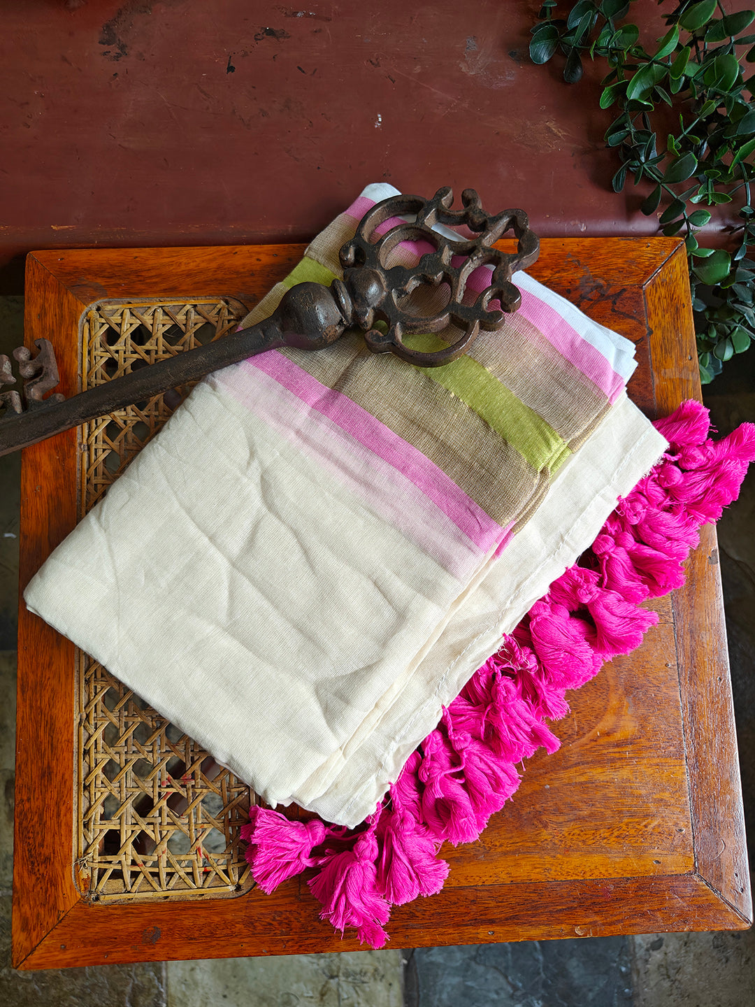 Textile with pink fringe on a wooden surface